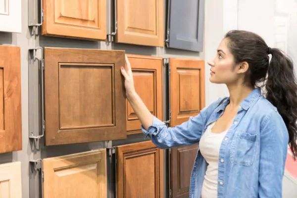Female Home Improvement Store Customer Examines Wooden Cabinets