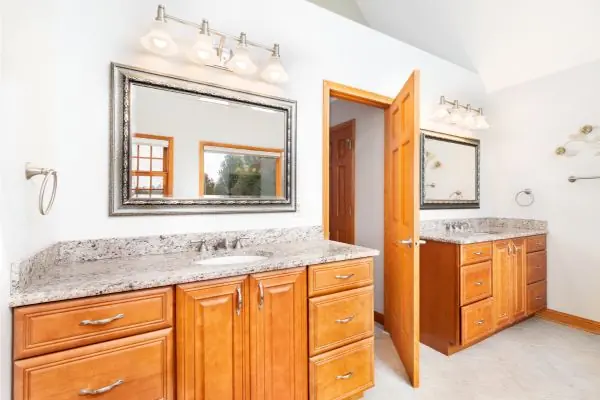 a bathroom with wooden cabinets and marble countertops