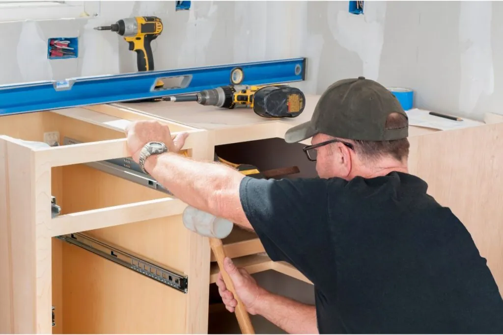 construction worker installing kitchen cabinets