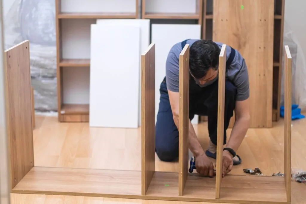 fixing furniture business skilled handyman screwing nails into cabinet