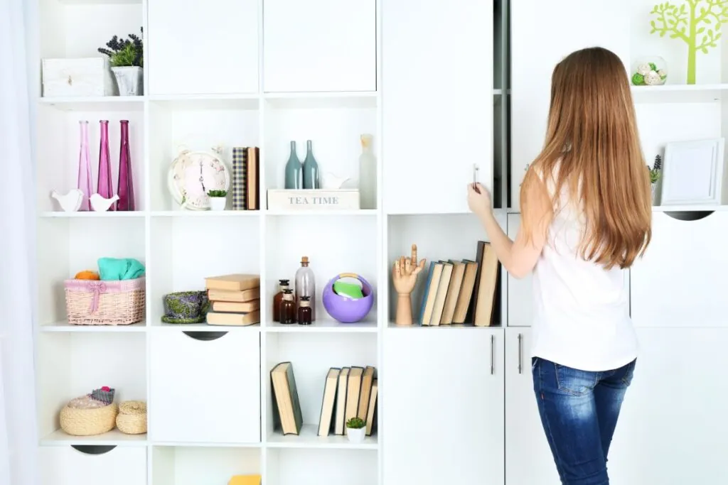 woman opening cabinet door on modern shelving unit