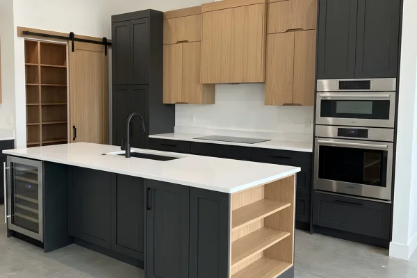 Modern custom kitchen with black and natural wood cabinets, white countertops, and open island shelving